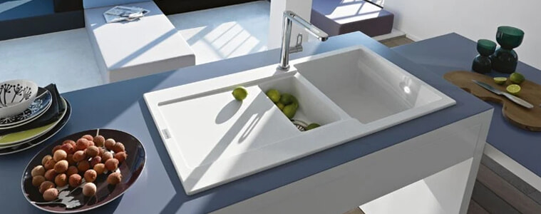 A white fragranite sink on a blue benchtop