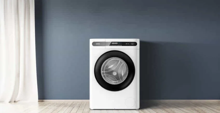 A CHiQ top load washing machine sits in a white laundry