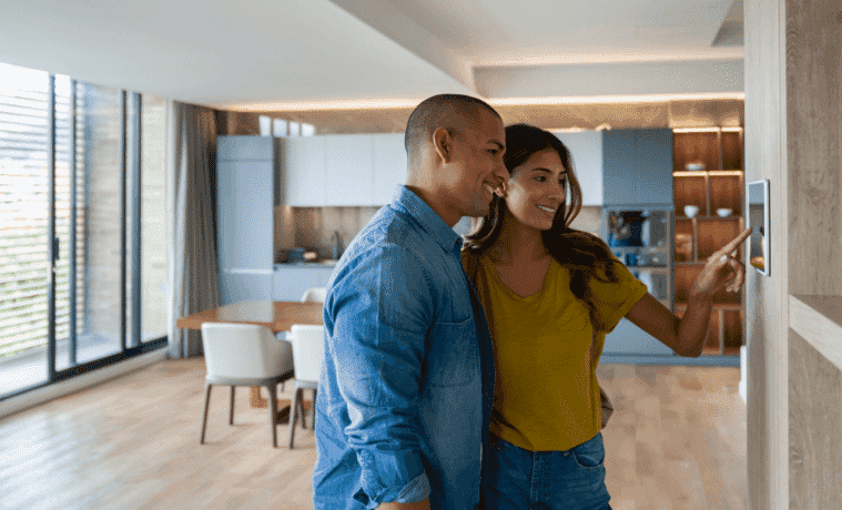 Happy couple controlling their smart house using an automated system from a tablet