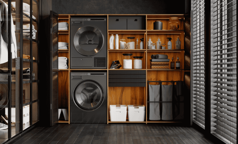 A black washer and dryer stacked on top of each other in a dark and moody laundry