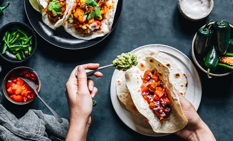 Closeup view of someone filling grilled flatbread for tasty tacos