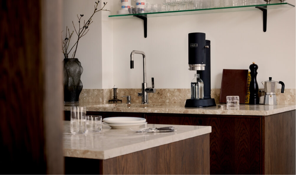 An aarke carbonator pro in matte black sitting on a modern kitchen bench