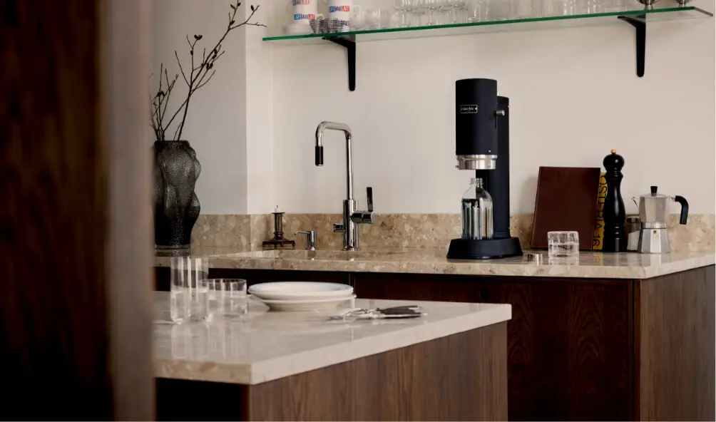 An aarke carbonator pro in matte black sitting on a modern kitchen bench