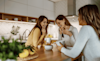 3 ladies sitting around a kitchen table drinking coffee