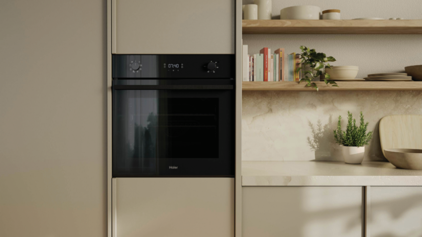 A chrome quad door Haier fridge sits in a modern kitchen with the top doors open displaying the fridges capacity 