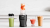 Image of smoothies and shakes lined up on a benchtop next to the Ninja Nutri Precision Blender Mega Pack