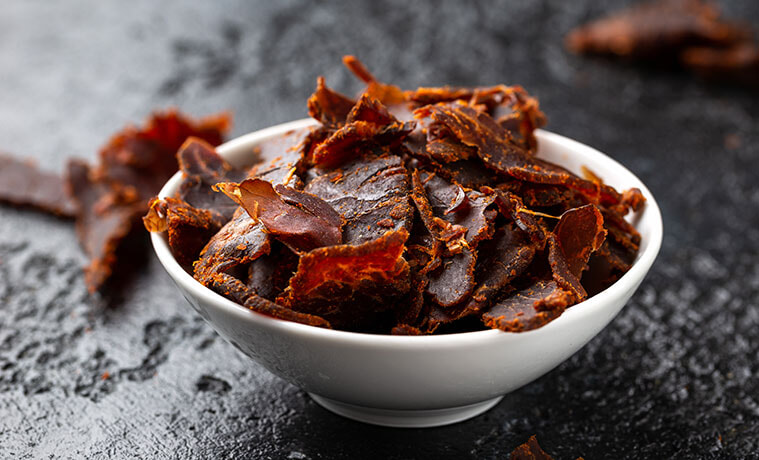 Dried beef jerky in a white snack bowl