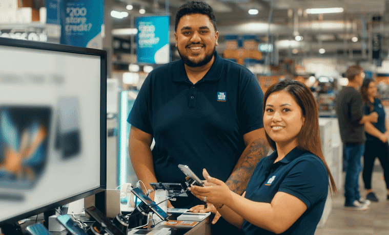 The Good Guys Team Members standing near a display of Phones 