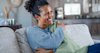 A woman on her couch underneath an electric blanket