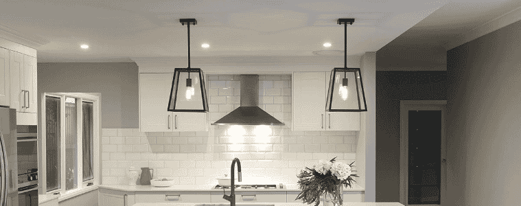 Two black pendant lights in a white Hamptons style kitchen