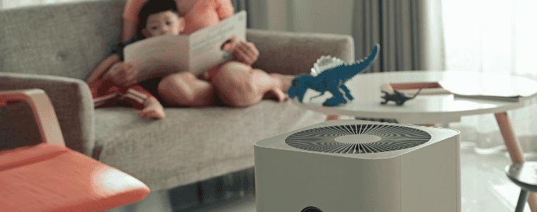 a mum reading her soon a book while they have the air purifier going 