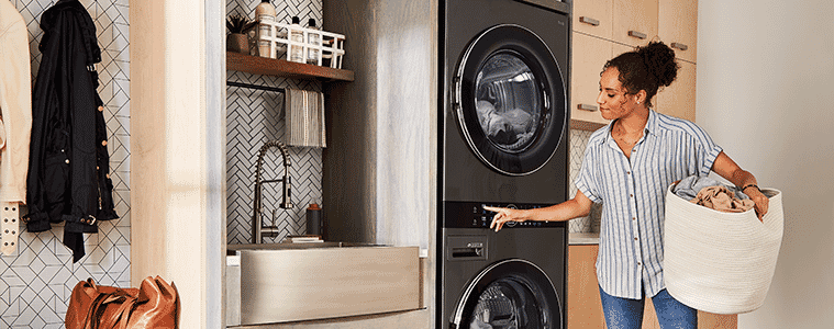 A woman prepares to remove a load from the dryer section of the LG WashTower