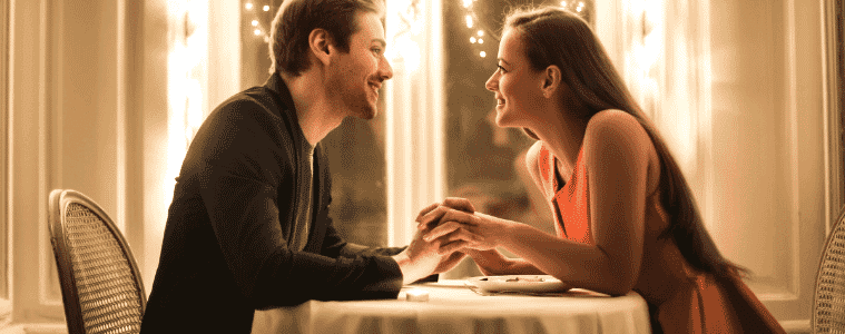 A sweet young couple enjoys a romantic dinner at home together