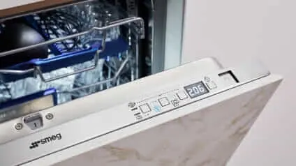 An open builtin Smeg oven with a marbled cabinet front