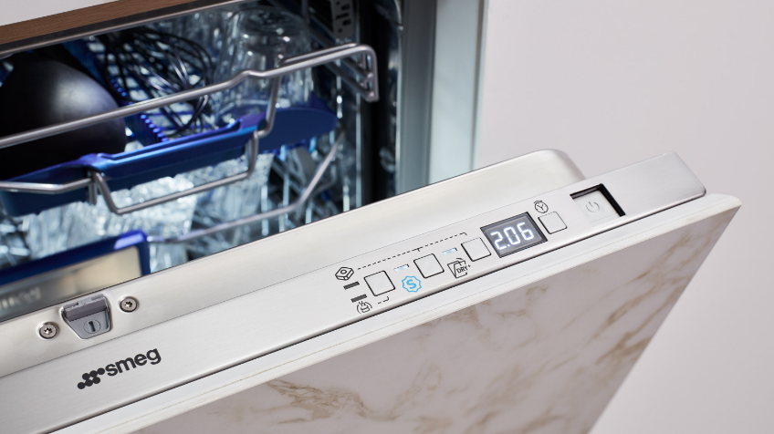 An open builtin Smeg oven with a marbled cabinet front