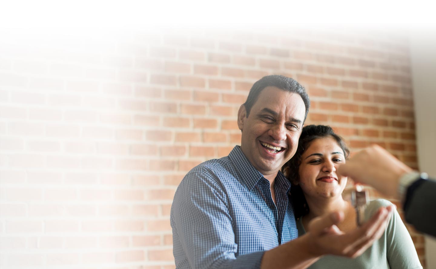 Foto de un señor con su esposa recibiendo las llaves de su nueva casa.