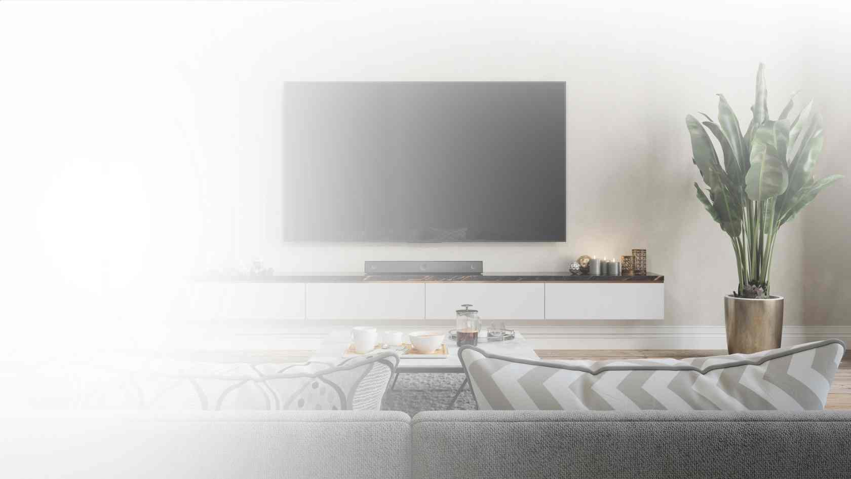 Televisor con barra de sonido en sala moderna.