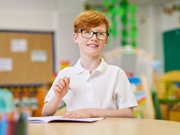 Ginger haired boy in glasses in a school classroom