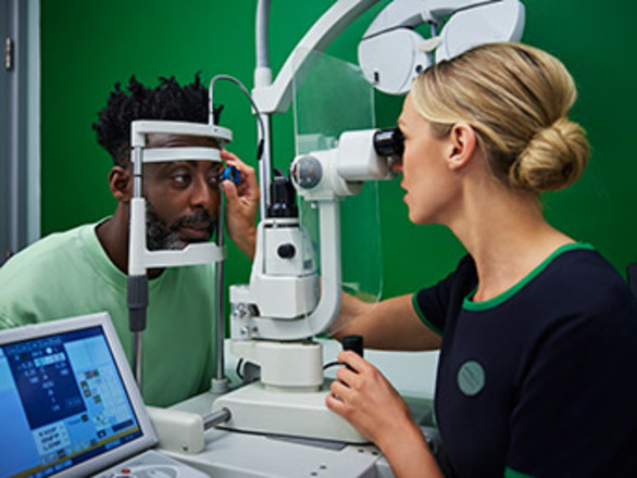 A Specsavers optician performs an eye test on a customer