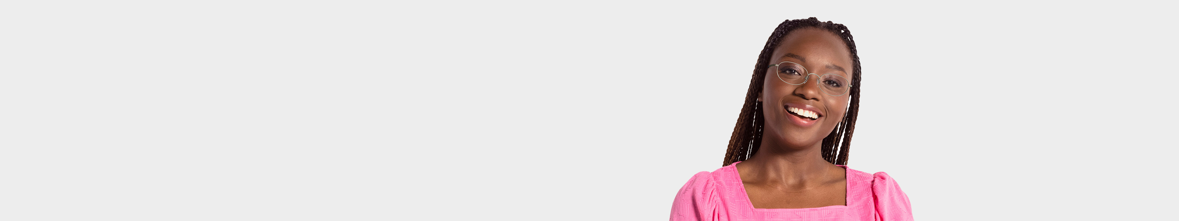 Lady with braided hair and a pink top wearing oval shaped glasses
