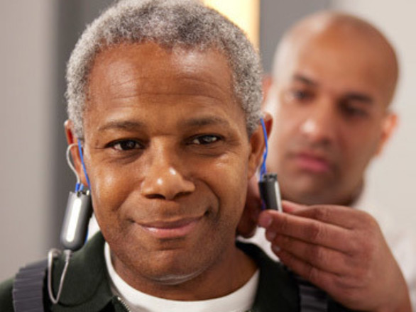 A man with grey hair has a hearing test from a Specsavers audiology