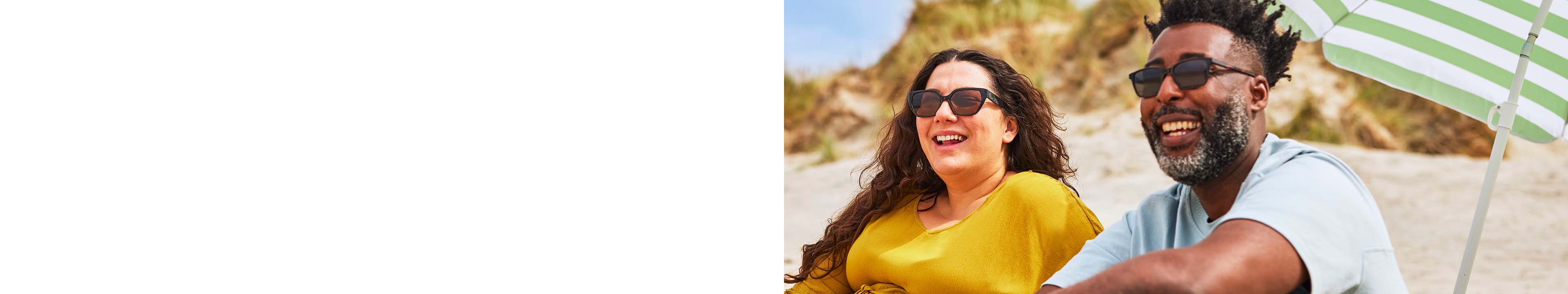 Couple on a beach wearing black sunglasses