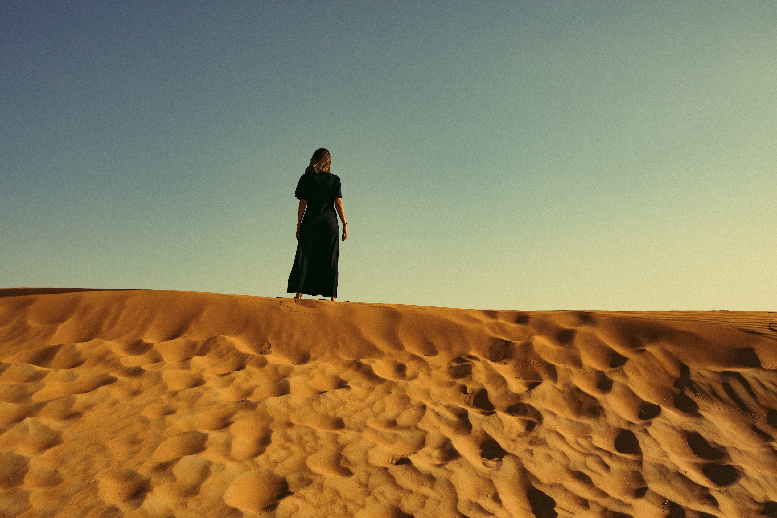Photo of a person standing alone in the desert.