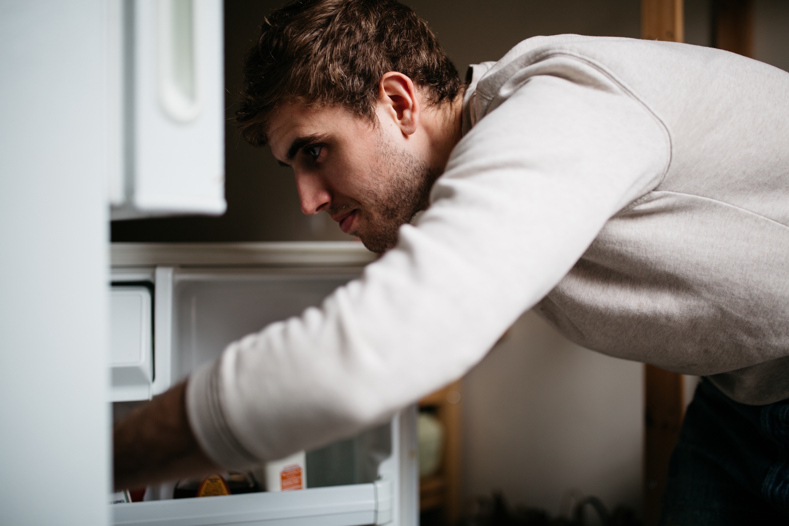 Photo of a person reaching into a refrigerator.