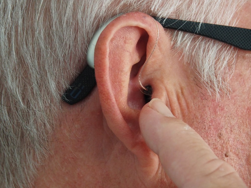 Elderly man with a hearing aid in that was not covered by Medicare.