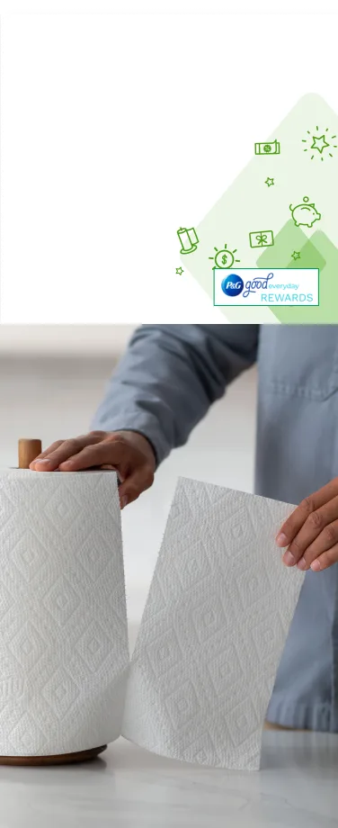 A person in a kitchen tearing off a Bounty paper towel sheet