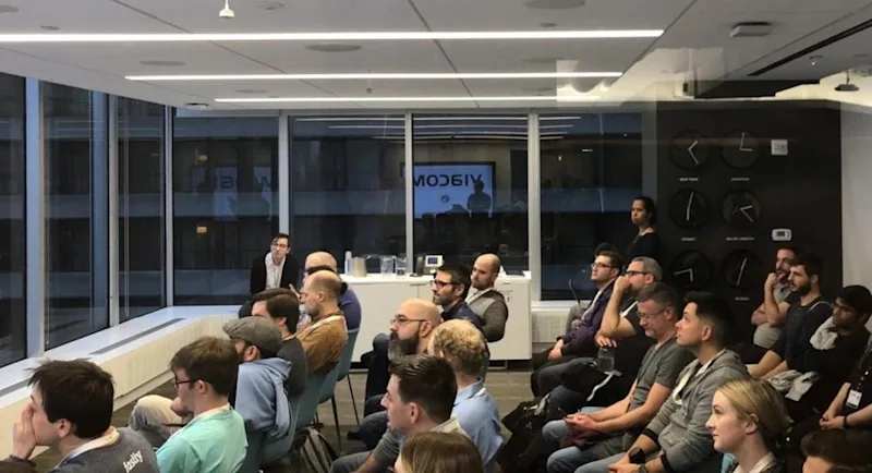 An audience watching a presentation in a conference room.