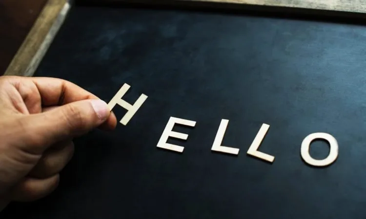 A chalkboard with the word hello being spelled out in letter shapes.