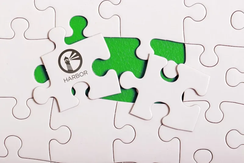 A white puzzle nearly complete with the Harbor logo on the remaining piece.