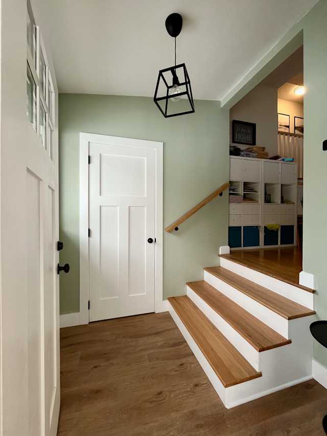 Barkway House - Foyer, Reducing the closet door created space for an additional step and, together with a new handrail, improved access to the main floor. New flooring, oak treads, and sage paint complete the contemporary update.
