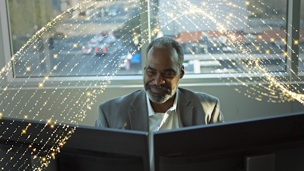 Professional man siting at computer with gold waves about him