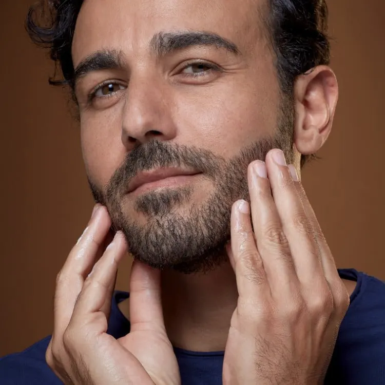 Mężczyzna nakładający na brodę balsam do brody King C. Gillette