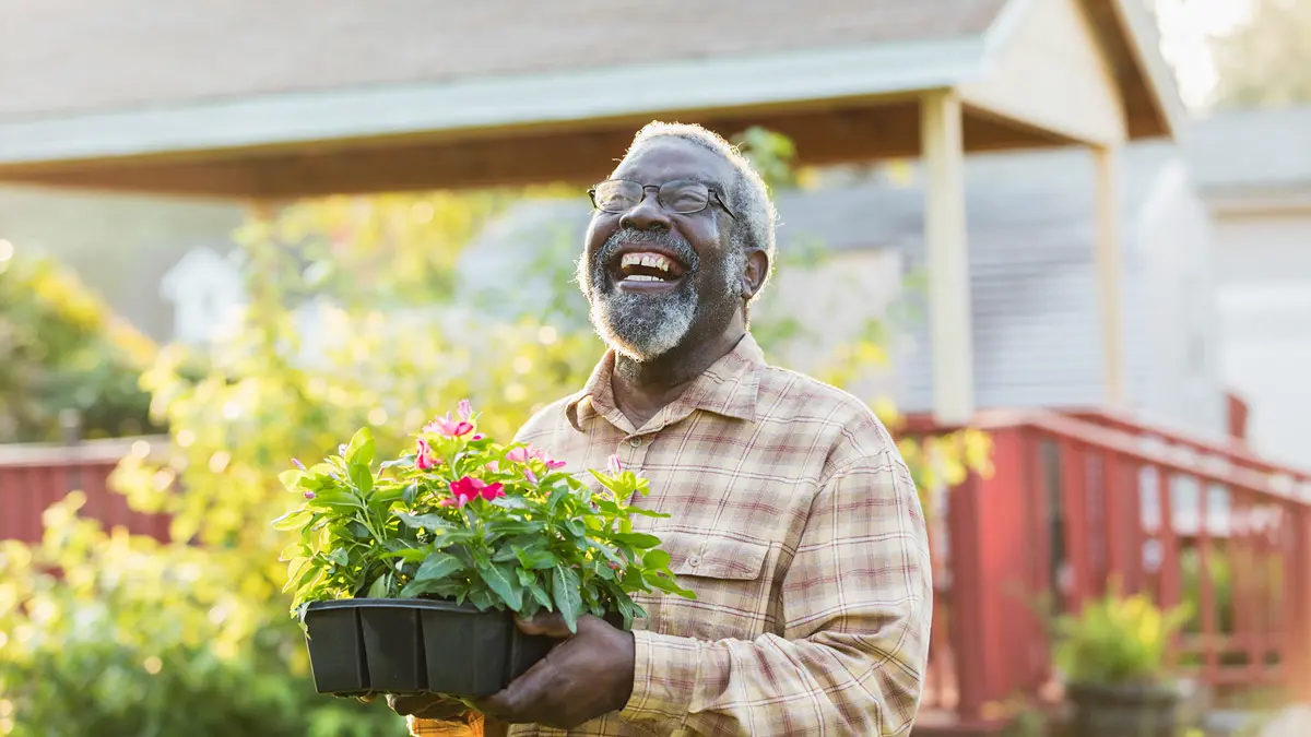 Man walking and smiling with flowers in his hands