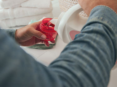 A man pouring detergent to a cup