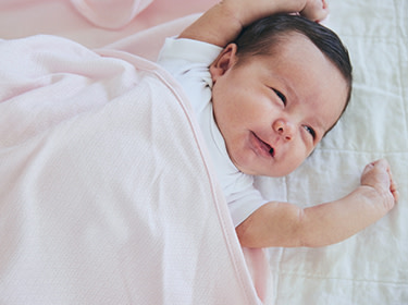 A baby laying in the bed