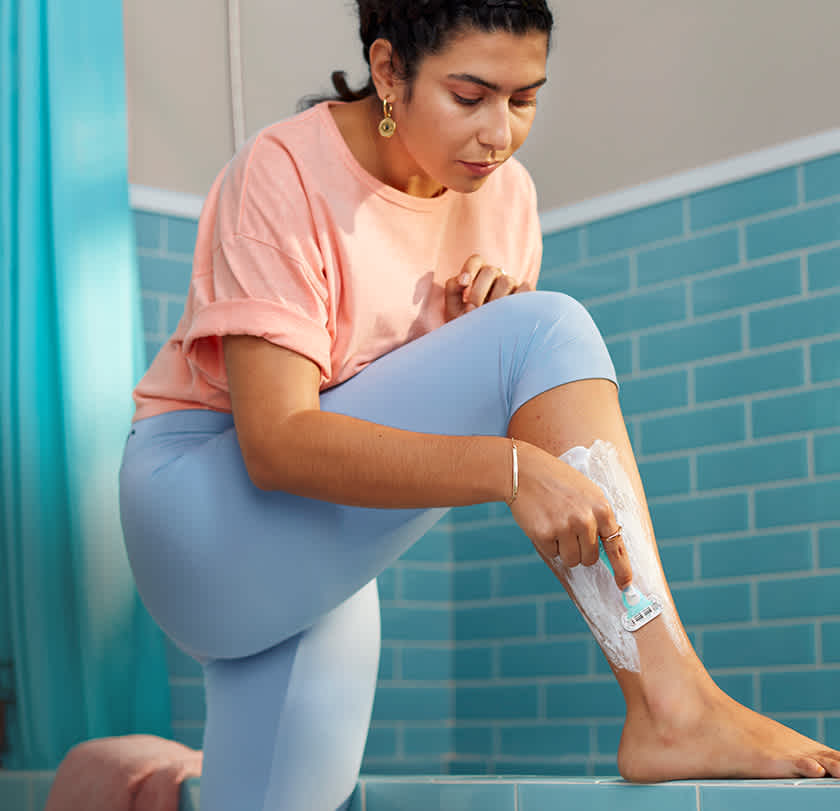 Donna che si rade la gamba con il rasoio usa e getta Gillette Venus Sensitive