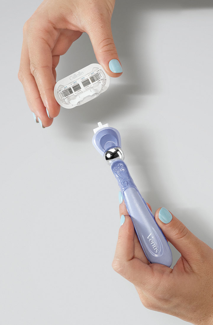 Una mano femminile con le unghie smaltate che monta una ricarica di lametta sul manico del rasoio Gillette Venus