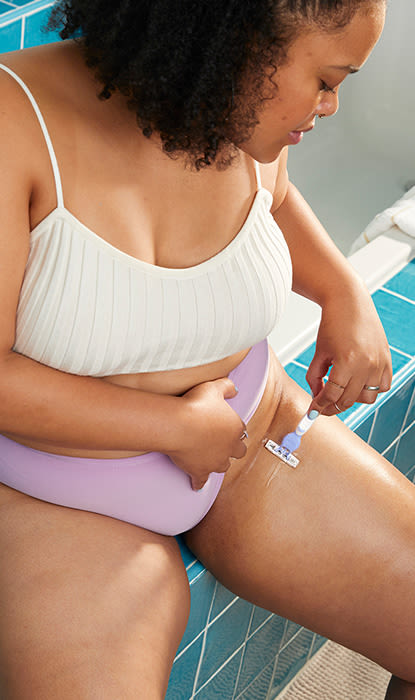 Una ragazza in bagno si depila la zona bikini