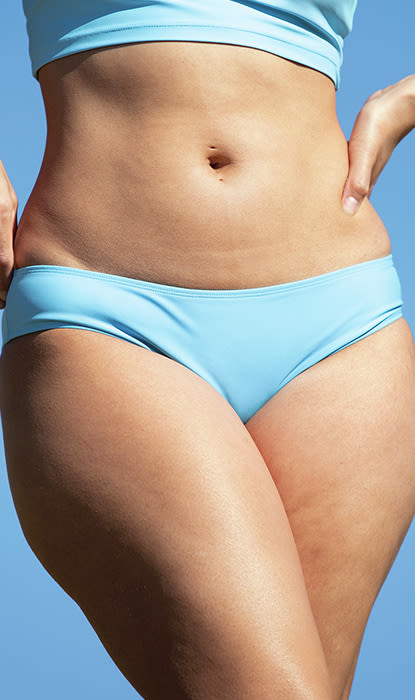 Una donna in bikini blu sotto un cielo limpido