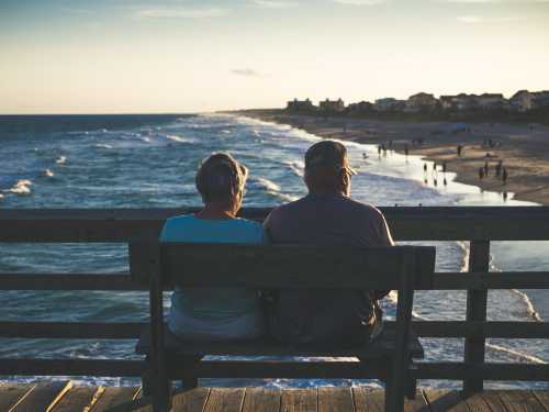 elderly couple sitting at a beach