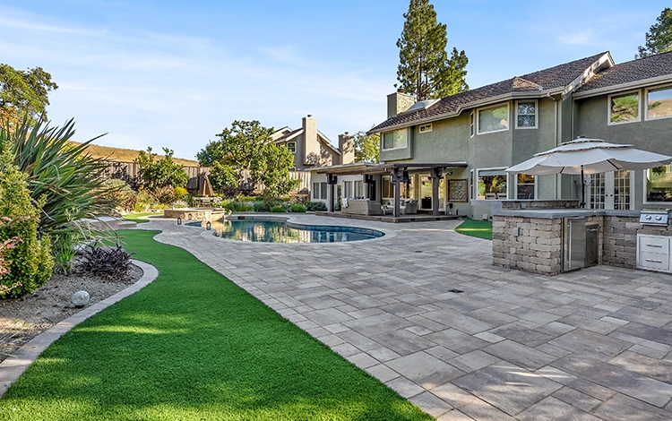 Incredible paving stone patio, kitchen and pool deck with turf. 