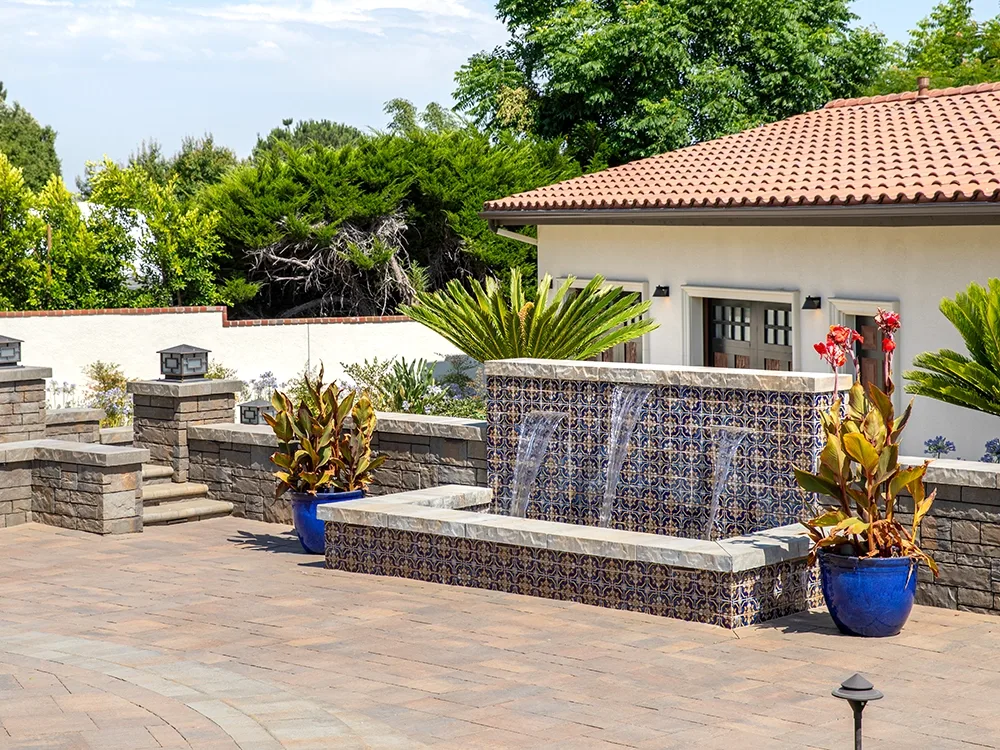 unique paver patio design with paving stone water feature and retaining wall