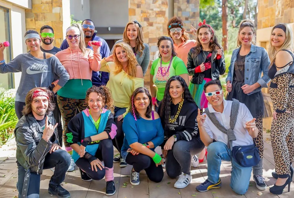Fun team dressed in 80s outfits during a company spirit day, showing off our playful and creative culture.