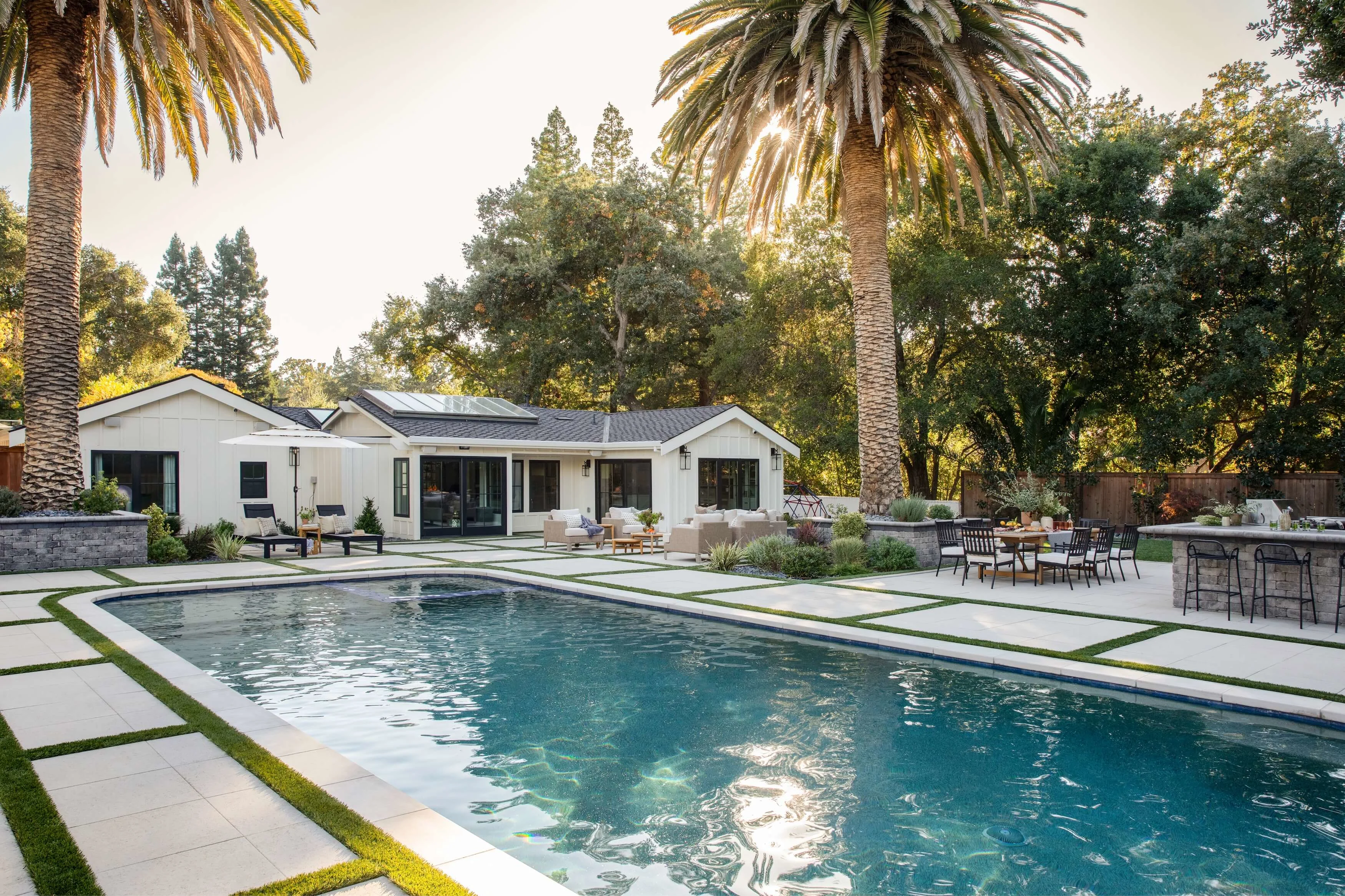 Stunning poolside oasis with paver pool deck, outdoor kitchen and multiple outdoor entertainment areas