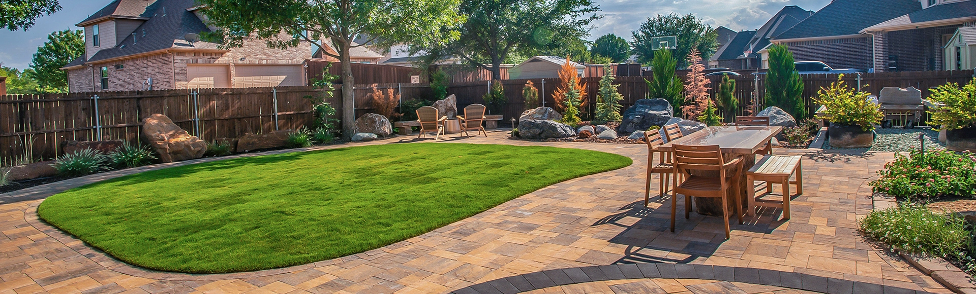 Backyard in Texas with paver patio, solo stove fire pit and turf. 