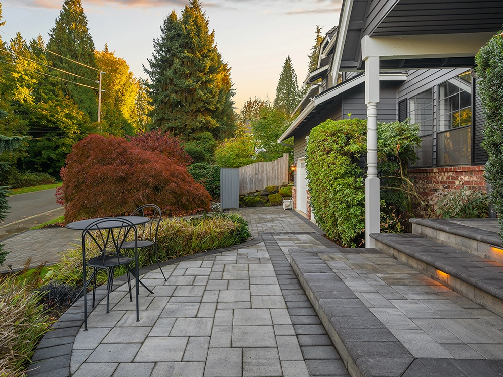 Beautiful front patio with paving stone steps and built-in lighting in Oregon. 